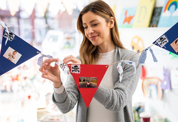 Woman attaching ribbons and cards to homemade bunting