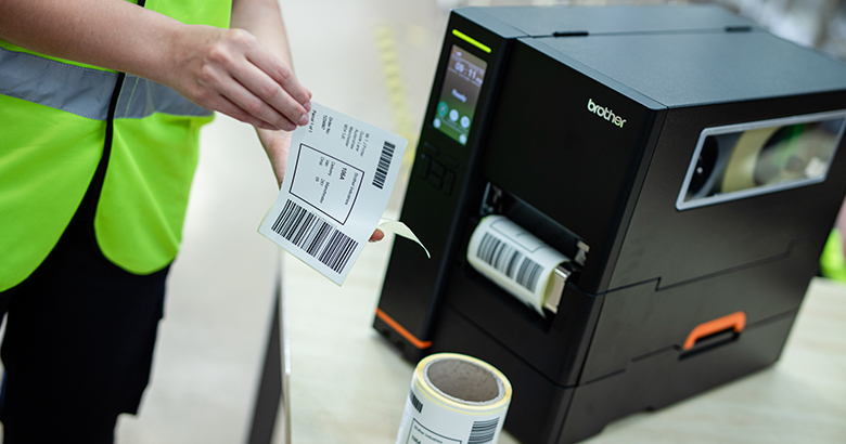 A factory worker holding an uncoated paper label 